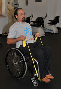 Man in wheelchair exercising with tension bands