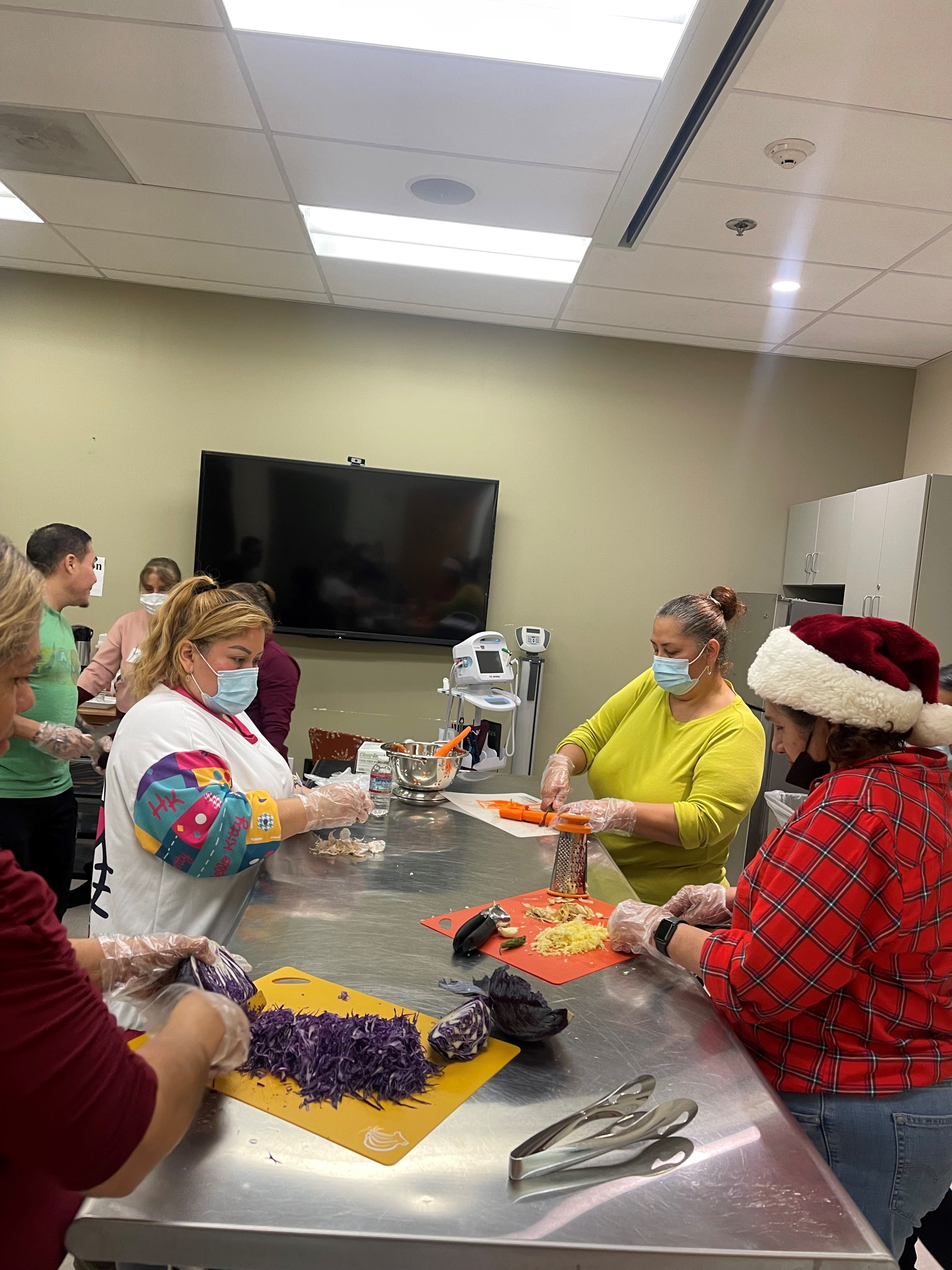 Image of people wearing masks and meal prepping in the Teaching Kitchen.