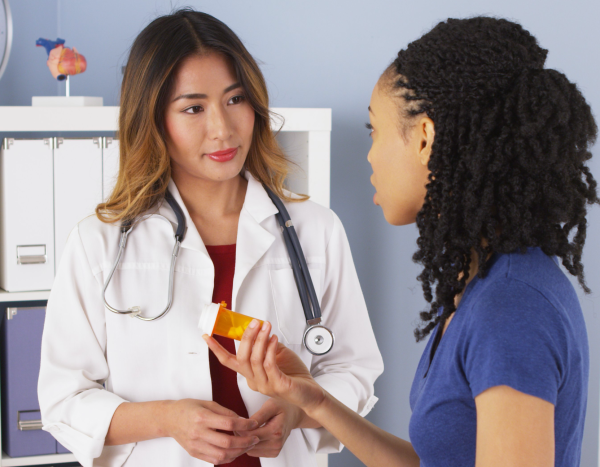 Health care provider talking with teen girl