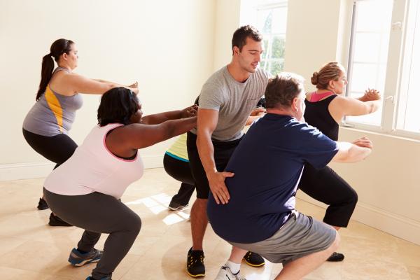 Un grupo de personas realiza ejercicios para la espalda. 
