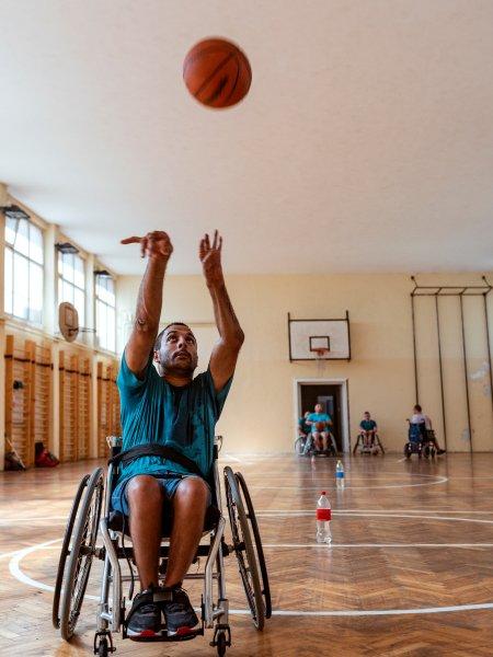 Jeff shoots a basketball from his wheelchair 