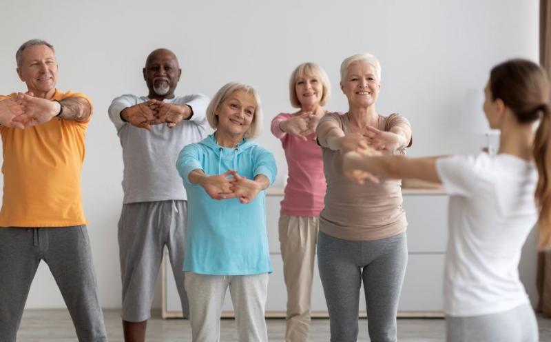 five older adults attend an exercise class led by an instructor
