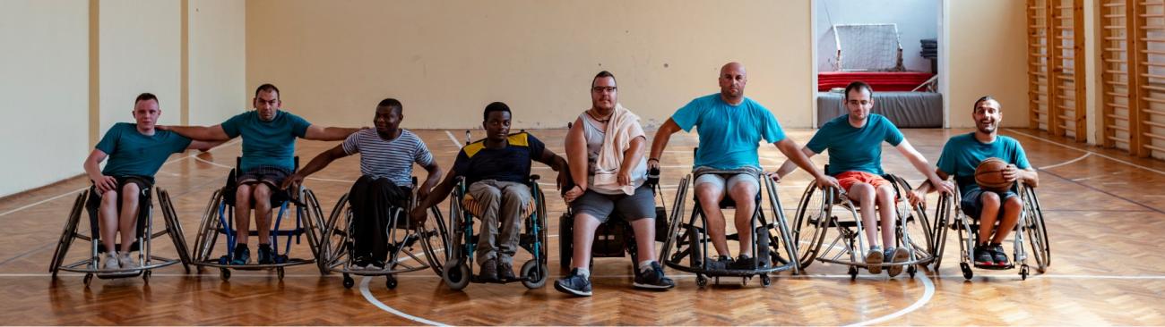 A group of men in wheelchairs on a basketball court