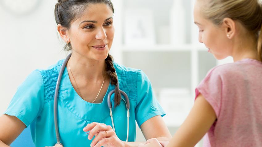 Health care provider talking with pre-teen girl