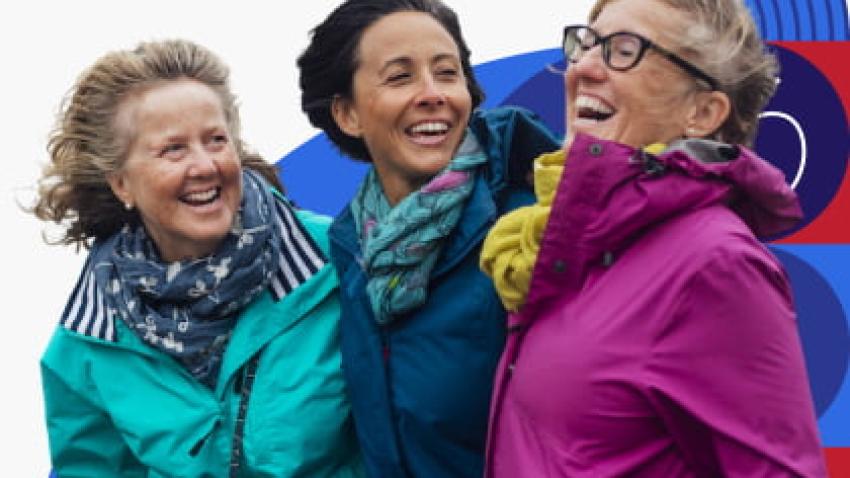 Three women hugging and laughing.